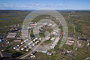 Aerial view of a northern town in the Arctic. There are many abandoned buildings in the settlement.