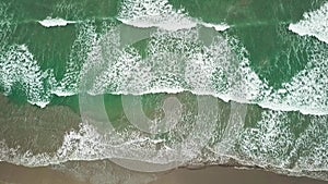 Aerial view ocean blue and green waves break on white sand beach. Sea waves on the beautiful beach aerial view drone