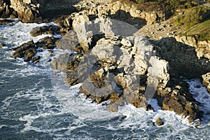 Aerial view of ocean crashing in on rugged rocks near Portland Headlight south of Portland, Maine