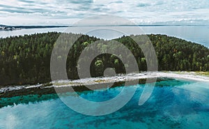 Aerial view ocean and uninhabited island with coniferous forest drone nature landscape