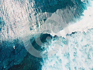 Aerial view of ocean water, waves and surfers at Bali island. Top view