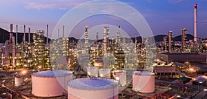 Aerial view oil and gas tank with oil refinery background at night, Glitter lighting of petrochemical plant with night,