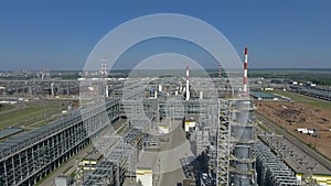 An aerial view of an oil refining complex against bright blue sky