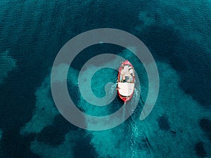 Aerial view of old fishing boat in blue sea in Greece