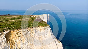 An aerial view of the Old Harry Rocks along the Jurassic coast with crystal clear water and white cliffs under a hazy sky