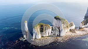 An aerial view of the Old Harry Rocks along the Jurassic coast with crystal clear water and white cliffs under a hazy sky