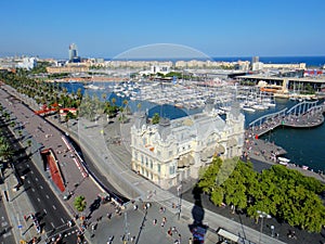 Aerial view the old port of Barcelona on a clear sunny day. Large cruise ships are moored to the pier.