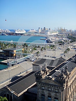 Aerial view the old port of Barcelona on a clear sunny day. Large cruise ships are moored to the pier.