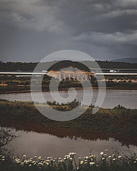 Aerial view of old stone castle on the lake shore under dark cloudy sky