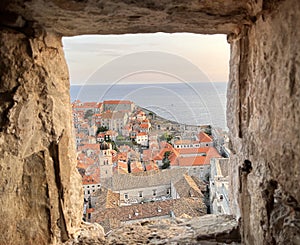 Aerial view of the old town of Dubrovnik framed through the window of a city wall