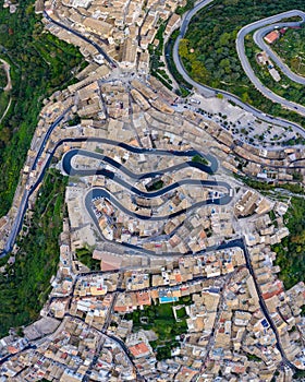 Aerial view of the old town of Ragusa Ibla and a winding road. View from above of the city in Ragusa Ibla, Province of Ragusa, Val