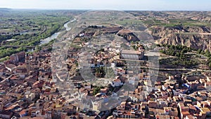 Aerial view of olt town of Fraga on bank of Cinca river in province of Huesca overlooking brownish tiled roofs of