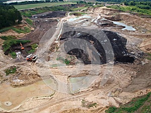 Aerial view on open pit mine of sand and hummus, flooded with water