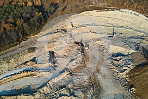 Aerial view of open pit mine of sandstone materials for construction industry with excavators and dump trucks. Heavy