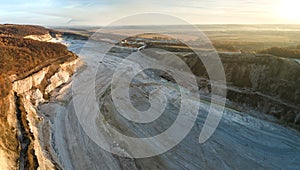 Aerial view of open pit mine of sandstone materials for construction industry with excavators and dump trucks. Heavy