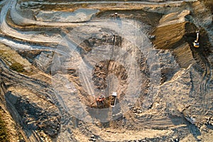 Aerial view of open pit mine of sandstone materials for construction industry with excavators and dump trucks. Heavy