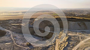 Aerial view of open pit mine of sandstone materials for construction industry with excavators and dump trucks. Heavy