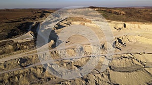 Aerial view of open pit mine of sandstone materials for construction industry with excavators and dump trucks. Heavy