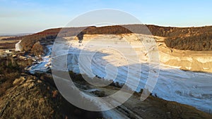 Aerial view of open pit mine of sandstone materials for construction industry with excavators and dump trucks. Heavy