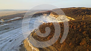 Aerial view of open pit mine of sandstone materials for construction industry with excavators and dump trucks. Heavy