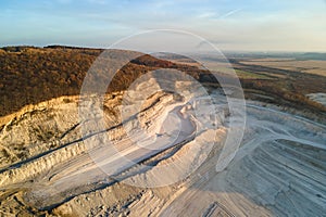 Aerial view of open pit mine of sandstone materials for construction industry with excavators and dump trucks. Heavy