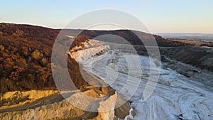 Aerial view of open pit mine of sandstone materials for construction industry with excavators and dump trucks. Heavy