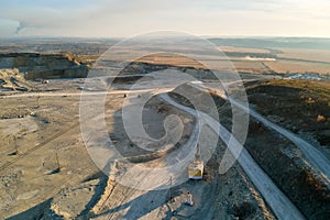 Aerial view of open pit mine of sandstone materials for construction industry with excavators and dump trucks. Heavy