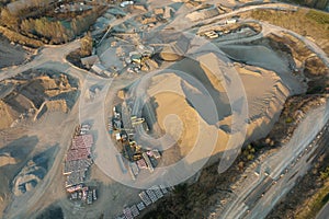 Aerial view of open pit mine of sandstone materials for construction industry with excavators and dump trucks. Heavy