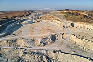 Aerial view of open pit mine of sandstone materials for construction industry with excavators and dump trucks. Heavy