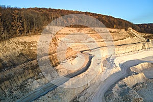 Aerial view of open pit mine of sandstone materials for construction industry with excavators and dump trucks. Heavy