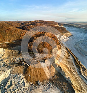 Aerial view of open pit mine of sandstone materials for construction industry with excavators and dump trucks. Heavy