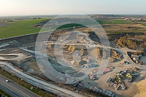 Aerial view of open pit mine of sandstone materials for construction industry with excavators and dump trucks. Heavy