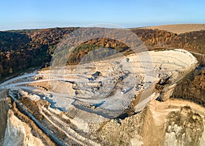 Aerial view of open pit mine of sandstone materials for construction industry with excavators and dump trucks. Heavy