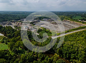 Aerial view of opencast mining quarry with lots of machinery at work in middle of forest on Pennsylvania, USA