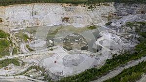 Aerial view of opencast mining quarry with lots of machinery at work - view from above.