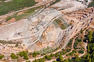 Aerial view of opencast mining quarry with lots of machinery at work view above. Area has been mined for copper, silver