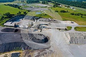 Aerial view of opencast mining quarry with of machinery at work quarries stones scattering on the working mine