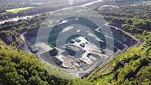 Aerial view of opencast mining quarry in the middle of the forest