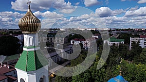 Aerial view of an orthodox church with bell towers and domes in a city block on a summer day