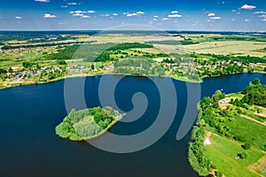 Aerial view of Ostrovno lakes, green fields and trees, small villages, summer on a sunny day, Belarus, Europe