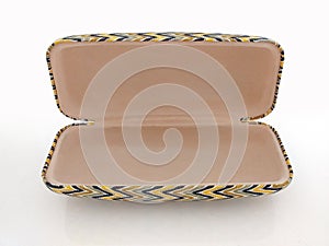 Aerial view of oval sunglasses case with ethnic design and open. Elegant large cover glasses on a white background