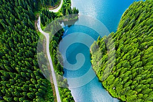 Aerial view over beautiful turquoise mountain lake and green forest. Spring in the mountains. Green forest, mountain lake. Green p