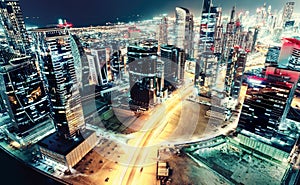 Aerial view over a big futuristic city by night. Business bay, Dubai, United Arab Emirates.