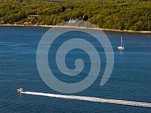 Aerial view over the calm waters with a sailboat traveling in Oyster Bay near Lloyd Harbor, New York