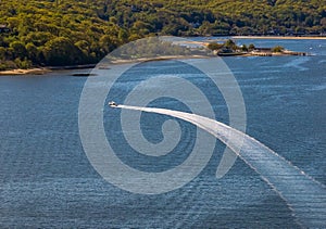 Aerial view over the calm waters with a sailboat traveling in Oyster Bay near Lloyd Harbor, New York