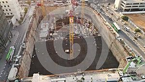 Aerial view over construction site at daytime. workers, engineers, cranes and concrete cement on site. big