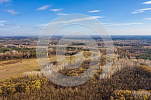 Autumn forest at dawn, aerial view. Autumn landscape, dry meadow fields with trees and blue sky