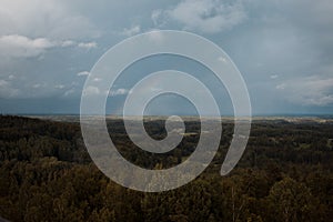 Aerial view over the green forest in evening. Cloudy mystery. Landscapes of Latvia.