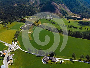 Aerial view over green meadow in Zgornje Jezersko, to Kamnik-Savinja Alps on a sunny summer day in Slovenia. Travel and tourism