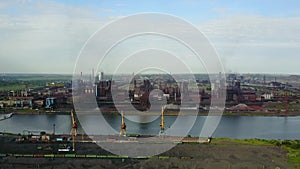 Aerial view over industrialized city with air atmosphere and river water pollution from metallurgical plant near sea